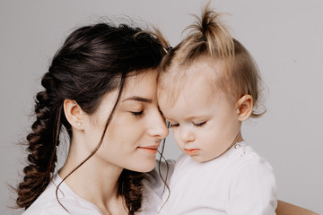 happy mother and daughter on shooting in the studio on a white background