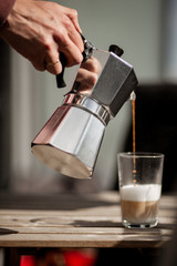 Fototapeta na wymiar Pouring morning coffee from a Mokka pot