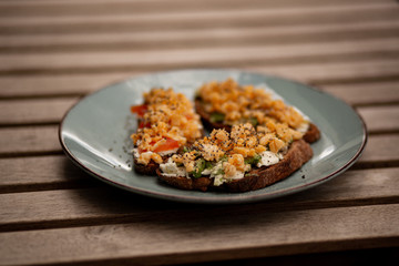 Avocado toasts with scrambled eggs, feta cheese and tomatoes