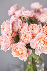 Flower shop delivery concept. Roses of multicolor, pastel pink and pale orange color. Lots of buds. Floral natural background