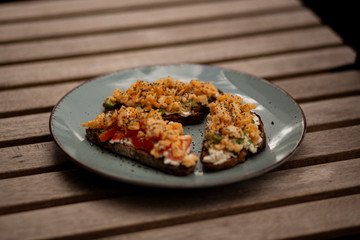 Avocado toasts with scrambled eggs, feta cheese and tomatoes