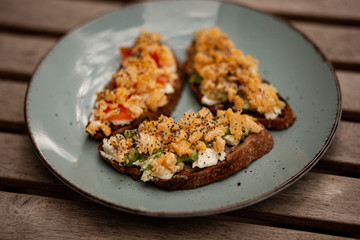 Avocado toasts with scrambled eggs, feta cheese and tomatoes