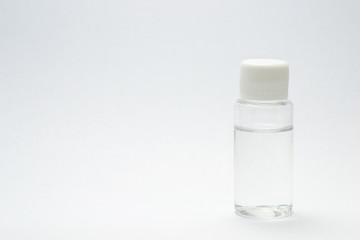 Transparent bottle filled with a transparent fluid isolated on a white background with copy space