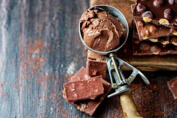 Vintage ice cream spoon and chocolate ice cream on a dark background, top view.