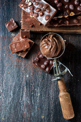 Vintage ice cream spoon and chocolate ice cream on a dark background, top view.