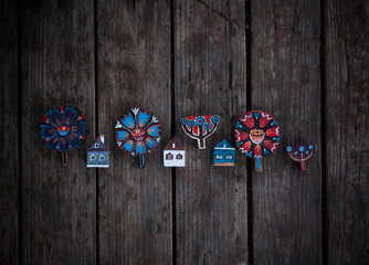 Fototapeta na wymiar Greeting card with wooden figures of houses,flowers,fishes,vintage folk style,scandinavian style