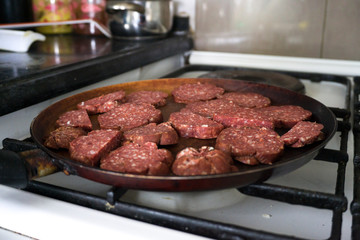 Top view of raw sausages being fried with hot cooking oil in a pan. Nutrition, clean eating, healthy lifestyle concept.