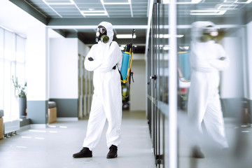 Man in protective hazmat suit in an empty office. Concepts to preventing the spread of coronavirus, pandemic in quarantine city. Covid -19.