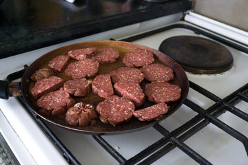 Top view of raw sausages being fried with hot cooking oil in a pan. Nutrition, clean eating, healthy lifestyle concept.