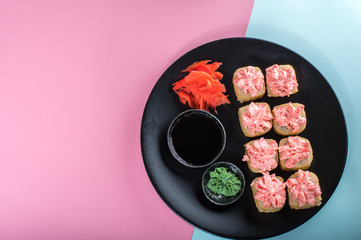 Top view on the plate of rolls with pink cream