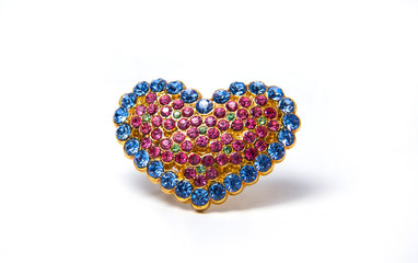 Brooch in the shape of a heart. Golden ornament in the shape of a heart. On white background. Precious stones