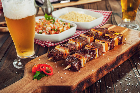 Grilled meat stick with beer and ingredients - Brazilian espetinho de carne