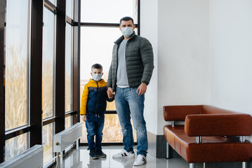 A father with his child stands in a mask during the quarantine. Pandemic, coronavirus