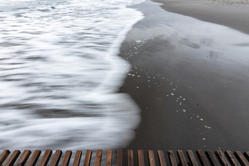 Wave rolls ashore, long exposure black and white photography