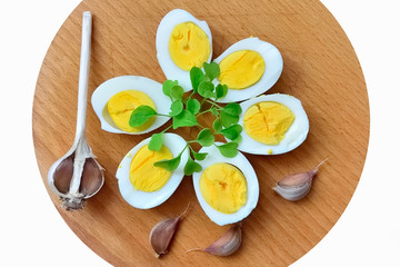 Boiled eggs with arugula sprigs and garlic closeup