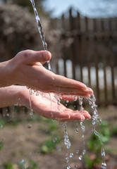  male hands under a stream of water .