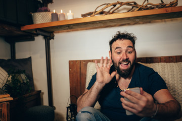 boy making a video call sitting on a sofa in a comfortable room during the lockdown for covid 19