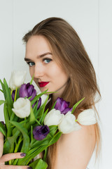 A beautiful girl is holding a big bouquet. A girl with a bouquet of tulips