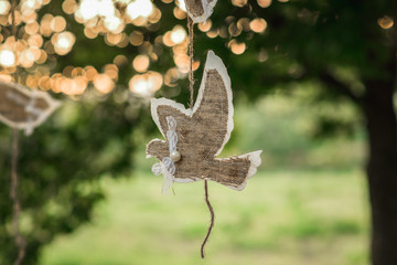 A beautiful close-up bird applique hangs during sunset on a branch