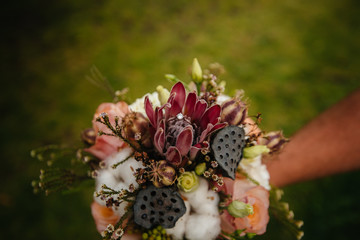 Wedding rings close-up on a beautiful wedding bouquet during sunset. Wedding accessories