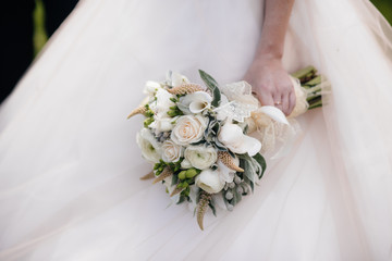 Beautiful and sophisticated wedding bouquet close-up holds the bride in her hands. Wedding bouquet