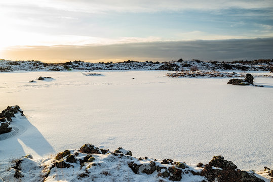 Iced lake in Vivistadir area in Gardabaer at sunrise, Iceland