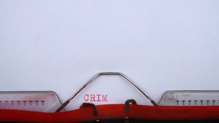 Criminal ordinance - phrase printed on an old typewriter in red letters, close up. vintage inscription