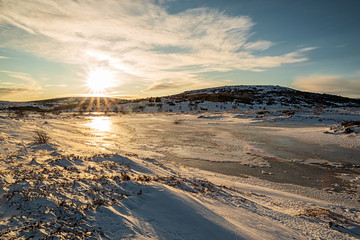 Iced lake in Vivistadir area in Gardabaer at sunrise, Iceland