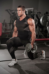 Fototapeta na wymiar Handsome Muscular Men Doing Lunges, Leg Exercise With Dumbbells in the Gym