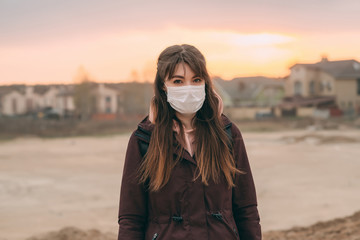 COVID-19 Pandemic Coronavirus Young girl in city street wearing face mask protective for spreading of Coronavirus Disease 2019. Close up of young woman with protective mask on face against SARS-CoV-2