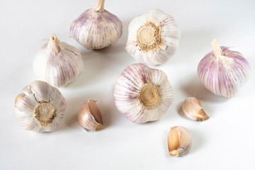 Garlic bulbs and garlic cloves on a white background.