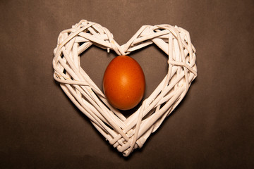 egg in the heart of white wooden branches on a gray background © havaji