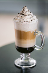 A coffee drink with whipped cream outside on a sunny day 
