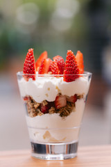 A yogurt parfait with strawberries on top