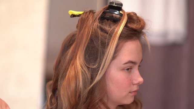 Girl hairdresser doing hairstyle in the form of spinning hair.