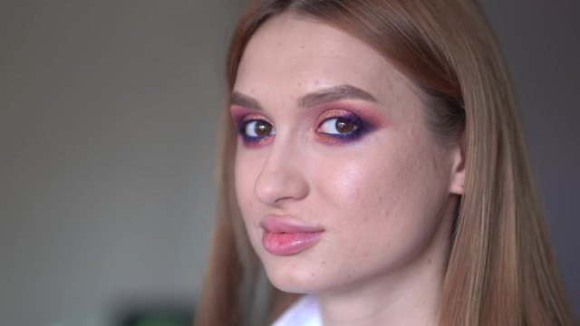 Makeup artist paints the eyes of a girl model