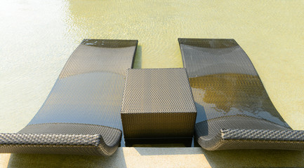 Beach chairs in luxury swimming pool.