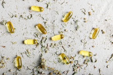 Light yellow pills capsules on a light orange background. Medicines, pharmacy, health, vitamins.