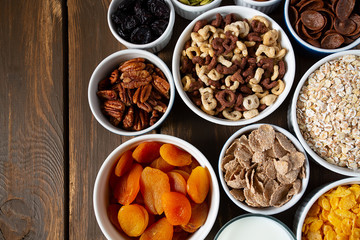 various cereals, nuts and dried fruits on wooden surface