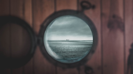 en esta imagen puedes ver la ventana de una casa en la playa, que muestra un gran barco en medio del océano