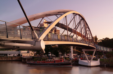 Brisbane goodwill Bridge with tug boat forcefull underneath at sunset