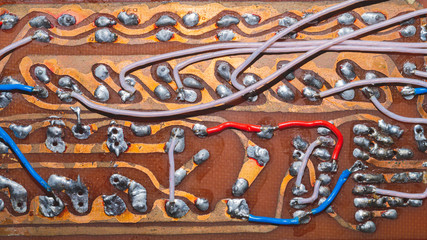 Handmade circuit board with connections and traces. colorful wires