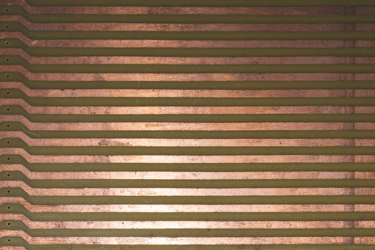 Parallel copper tracks on circuit board close up. industrial background