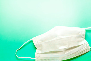 右に白いマスクと青緑系バックと左にコピースペース