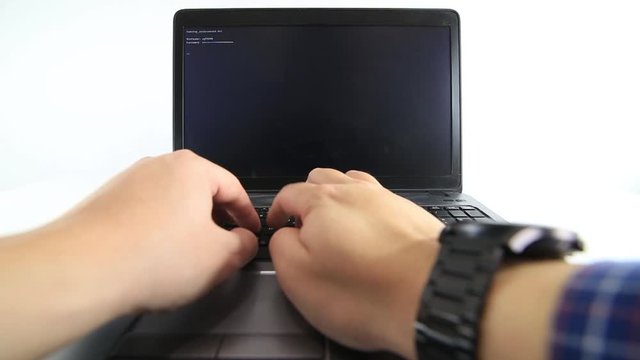 Hacker writing code on a laptop on white background