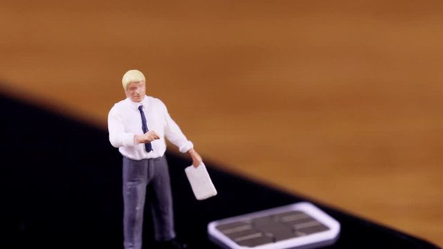 スマートフォンのSIMカードについて説明するビジネスマン　チルトダウン