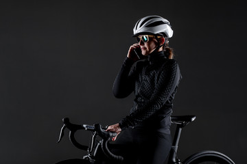 Girl posing on roadbike. White protective helmet and fashion sunglasses. Talking on cell phone....