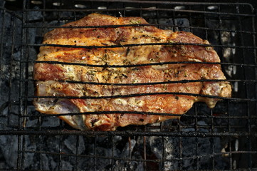 Beef steak on the grill with flames.