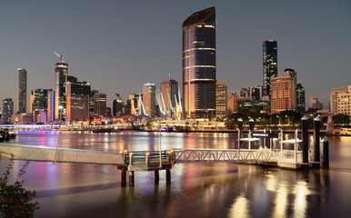 South bank Brisbane river sunset with the city cat pier dock jetty and city background glowing - obrazy, fototapety, plakaty