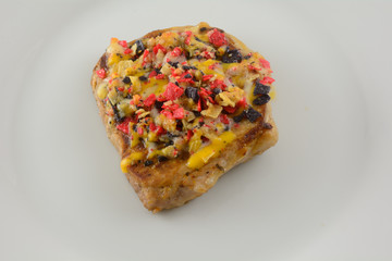 Closeup of baked boneless pork chop with cheese and toppings on whiter plate